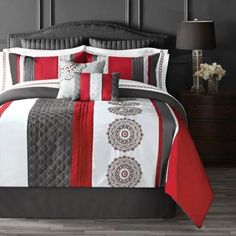 a bed with red and white comforters in a room