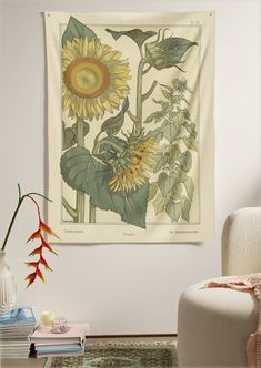 a large sunflower is hanging on the wall next to a white chair and vase