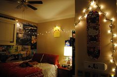 a bedroom decorated for christmas with lights on the ceiling and skateboards mounted to the wall