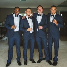 four men in tuxedos posing for the camera