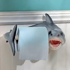 a shark toilet paper holder is hanging on the wall