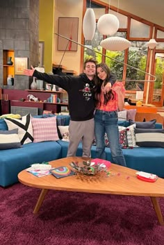 a man and woman standing in front of a coffee table