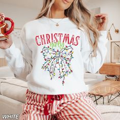 a woman wearing christmas lights sweatshirt and pajama pants