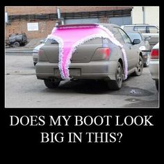 the back end of a car that is decorated with pink and white ribbon on it