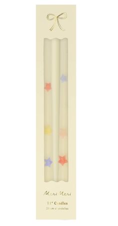 two white candles with colorful stars on them