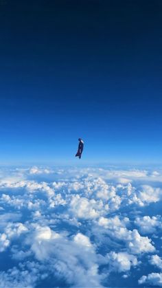 an airplane is flying high above the clouds