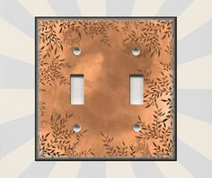 a light switch cover with an artistic design on it's copper plated surface