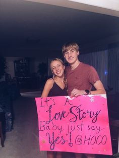 two people holding a sign that says it's a love story baby just say yes