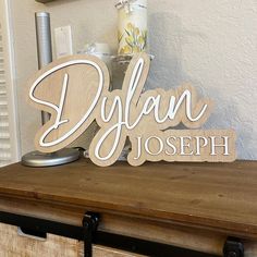 a wooden sign that says, diylan joseph on top of a table with other items