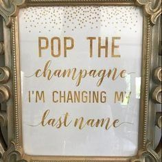 a gold framed sign that says pop the champagne i'm changing my last name