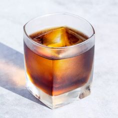 a glass filled with ice sitting on top of a table