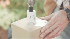 a man is working on an electronic device with a box in the foreground and trees in the background