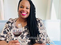 a smiling woman holding a glass of wine