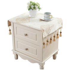 a white table with two drawers and a cup on top