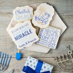 decorated cookies with blue and white designs are on a table next to a hanukkah menorah