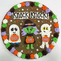 a decorated cookie with halloween characters on it that says knock knock trick or treat in the center