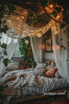 a bed with white curtains and lights hanging from it's headboard, surrounded by greenery