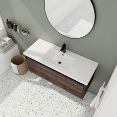 a white sink sitting under a round mirror