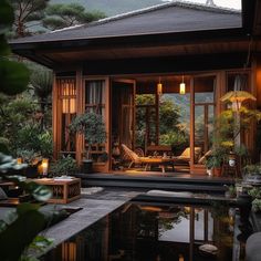 a house with a pool in front of it and lots of greenery around the outside