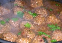 meatballs are being cooked in a large pot