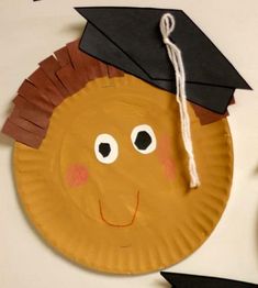 a paper plate with a graduation cap on top of it and a tassel hanging from the side