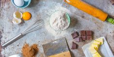 an assortment of ingredients are laid out on a baking sheet, including eggs, flour, butter, and chocolate