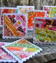 small cards with colorful designs on them sitting on top of a piece of wooden plank