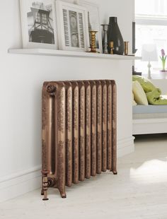 a radiator in the corner of a room next to a wall with pictures on it