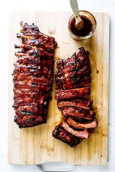 barbecue ribs on a cutting board with bbq sauce