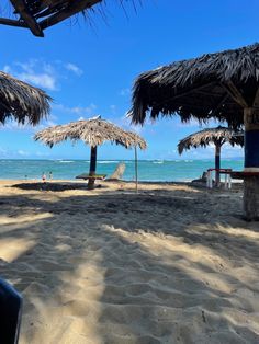 some straw umbrellas and chairs on the beach