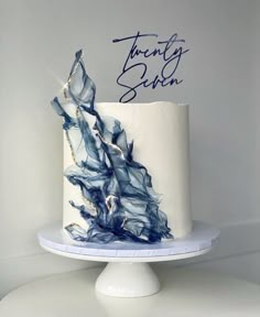 a white cake with blue icing and writing on top