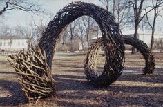 two sculptures made out of branches in a park