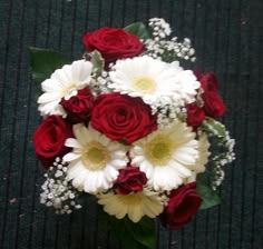 a bouquet of red roses and white daisies