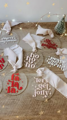 christmas ornaments on a wooden table with white and red ribbon around them that say merry christmas