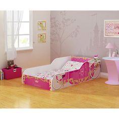 a child's bedroom with pink furniture and accessories