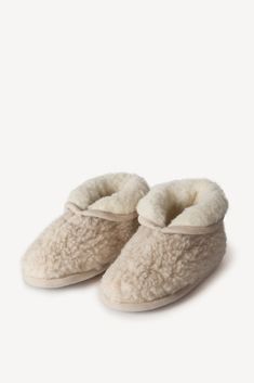 a pair of slippers with sheepskins on them, one is white and the other is beige