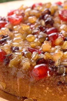 a close up of a cake on a wooden plate with nuts and jelly toppings