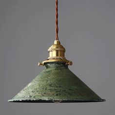 a green and gold colored light hanging from a ceiling fixture with a rope attached to it