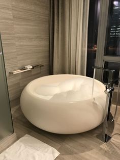 a large white bath tub sitting next to a walk in shower