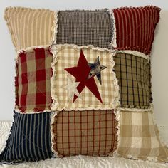 a decorative pillow made out of plaid fabric with a red star on the front and blue stars on the back