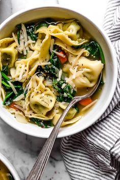 two bowls filled with pasta and spinach soup