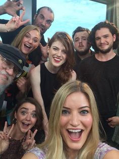 a group of people posing for the camera with their hands in the air and smiling