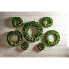 a group of green wreaths sitting on top of a wooden floor