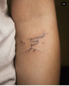 a woman's arm with a tattoo on it that has stars in the sky