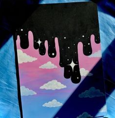 a painting with clouds and stars hanging from it's sides in front of a blue background