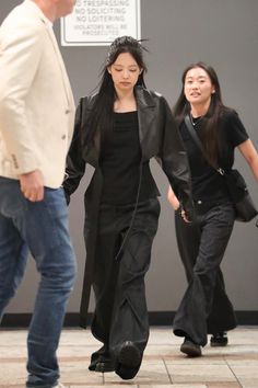 two people walking down the street with one woman in black