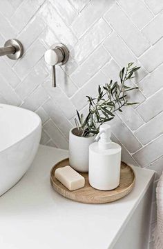 a bathroom sink with soap and an olive branch in the bowl on the counter next to it