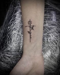 a small rose tattoo on the ankle is shown in black and white ink, with an arrow