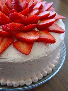 a cake with white frosting and fresh strawberries on top