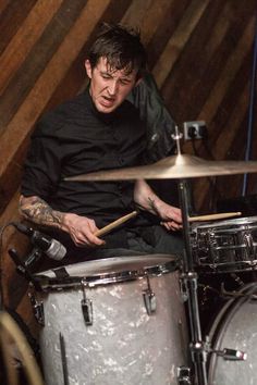 a man sitting on top of a drum set